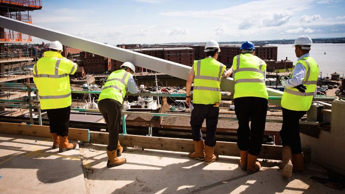 a group of builders on site wearing high visibility jackets